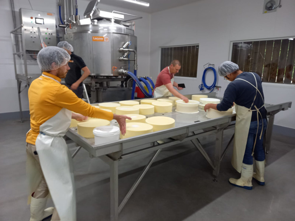 trois personnes travaille dans la nouvelle fromagerie avec la cuve de fabrication dans le fond. Cette nouvelle fromagerie permet de produire plus de fromage normand bio d'exception